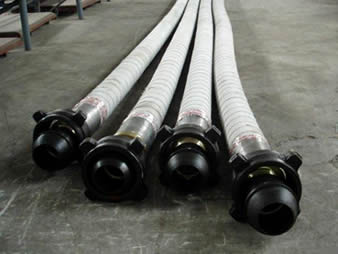 Several cement hoses are on the floor of a workshop.