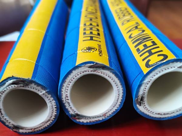 Many blue and green universal chemical rubber hoses are displayed.