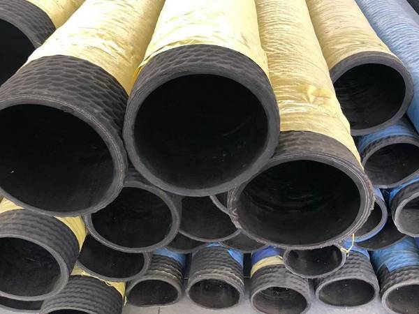 Many yellow mud suction and discharge hoses are placed on the ground.