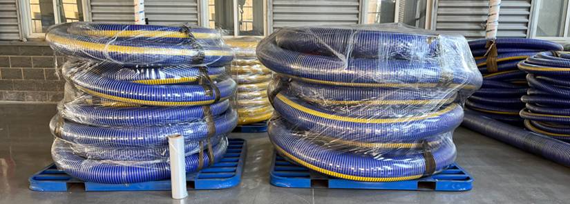 Many coils of suction and discharge composite hoses are displayed.