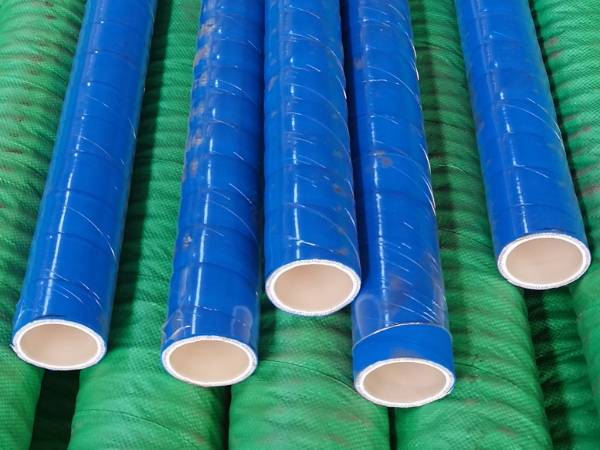 Many blue and green universal chemical rubber hoses are displayed.