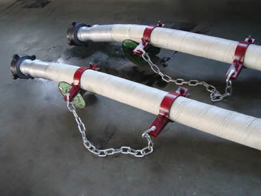 Two white rotary drilling hoses are on the floor of a workshop.